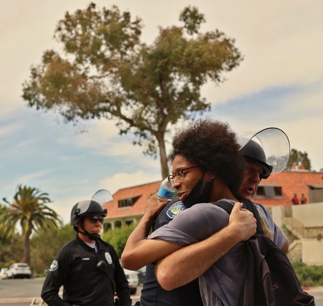 officer hugging citizen