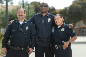 three police officers standing smiling officer survey