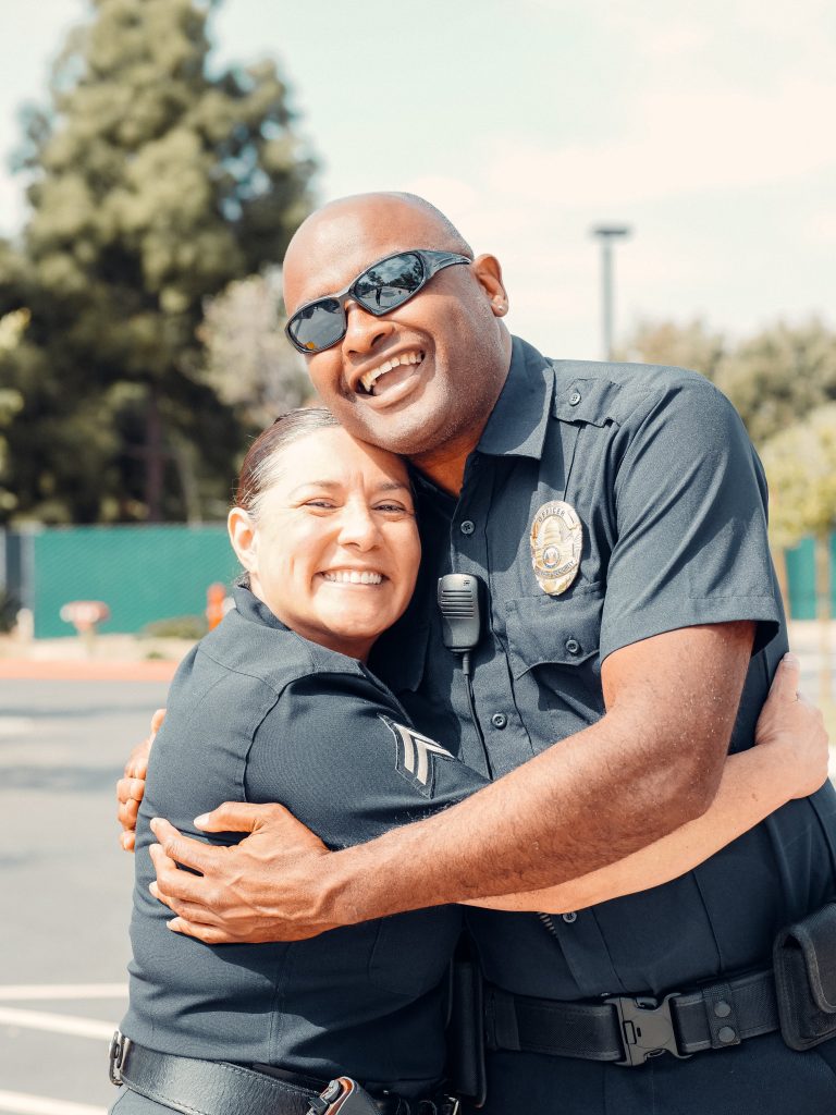 two police officers hugging